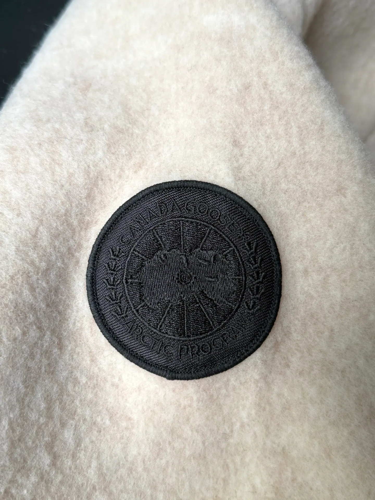 P620 Canada Goose Fleece Wool Baseball Jacket Fabric selection: Wool fleece fabric blended with wool as the main body and a very small amount of spandex and polyester fiber. Wool is a core natural ingredient that provides unparalleled temperature regulation, antibacterial and anti-odor properties and a skin-friendly feel. The feeding of a small amount of spandex gives the fabric a certain degree of four-way elasticity, making it non-restrictive during daily activities. As the basis of fleece's structure, polyester fiber enhances the fabric's durability, wrinkle resistance and quick-drying properties. It contributes to the loft of the fleece and provides functions such as trapping air.  Detail 1: The sleeves and hem are closed with 2×2 ribbing. Its strong elasticity can closely fit wrists and waists of different thicknesses, forming an effective 'seal' to prevent cold wind from blowing back. It can still maintain its original shape after repeated stretching and use, and is not easy to loose and deform. And the ribbed cuffs can convey a sense of design and enhance the visual beauty.  Detail 2: The combination of hood design and elastic buckle improves warmth and windproof performance when wearing. Accessories: Customized elastic drawstring, elastic buckle, custom zipper pendant, custom armband Size: S M L Color: Black Gray Mickey